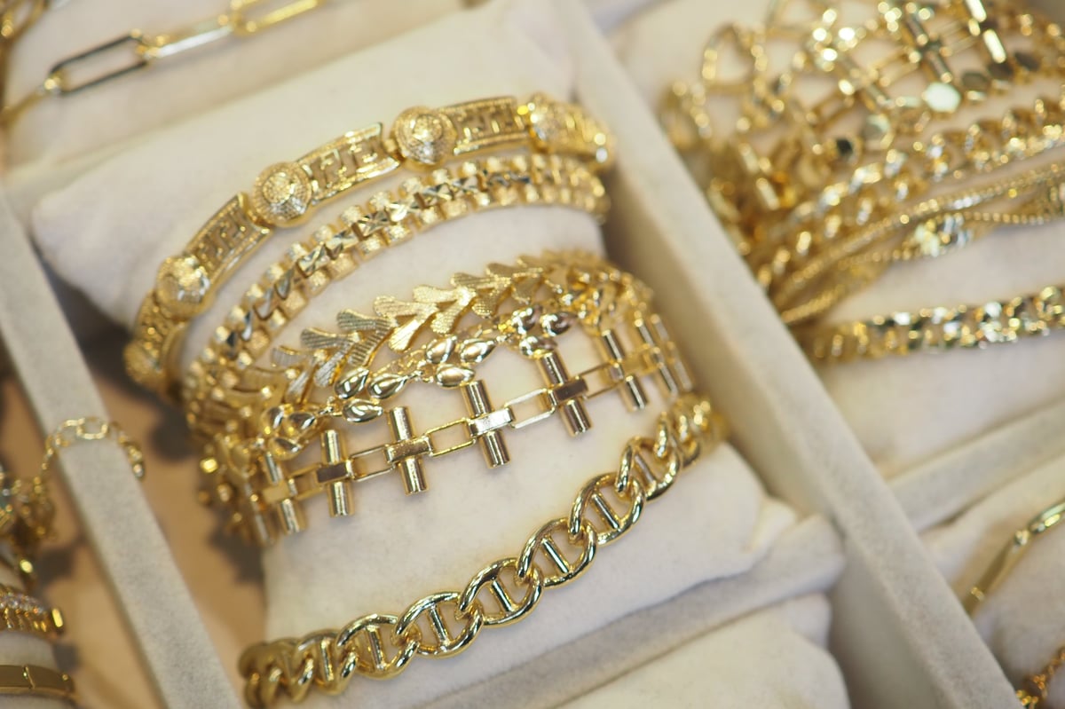 Various intricate gold bracelets arranged neatly in a jewelry display