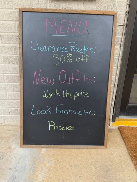 Chalkboard menu sign in multicolored chalk advertising clearance racks, new outfits, and a Look Fantastic promotion